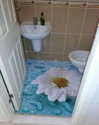 Lavabo pequeno com piso epóxi 3D representando uma flor branca gigante e gotas de água em azul.