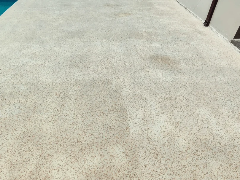 Piso bege texturizado com microesferas coloridas distribuídas de forma homogênea, criando efeito antiderrapante.